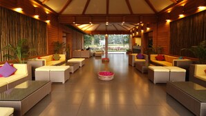 Un espacio interior amplio con diversas disposiciones de asientos, incluyendo sofás y sillones, organizados en una distribución simétrica.