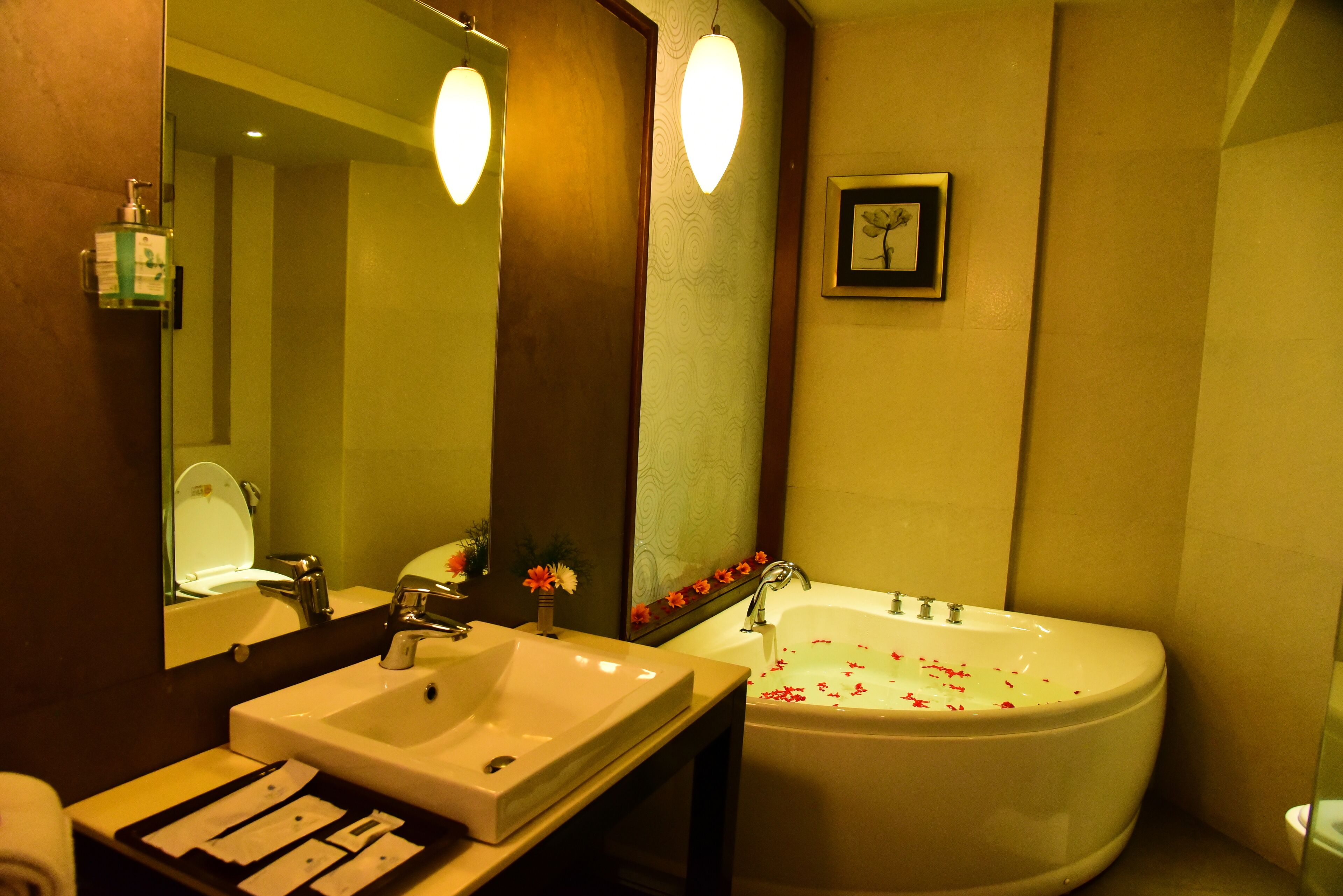A bathroom with a sink, mirror, and bathtub.