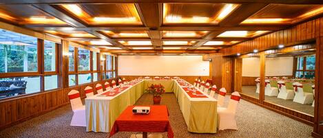 A conference room with a long table, chairs, and a projector.