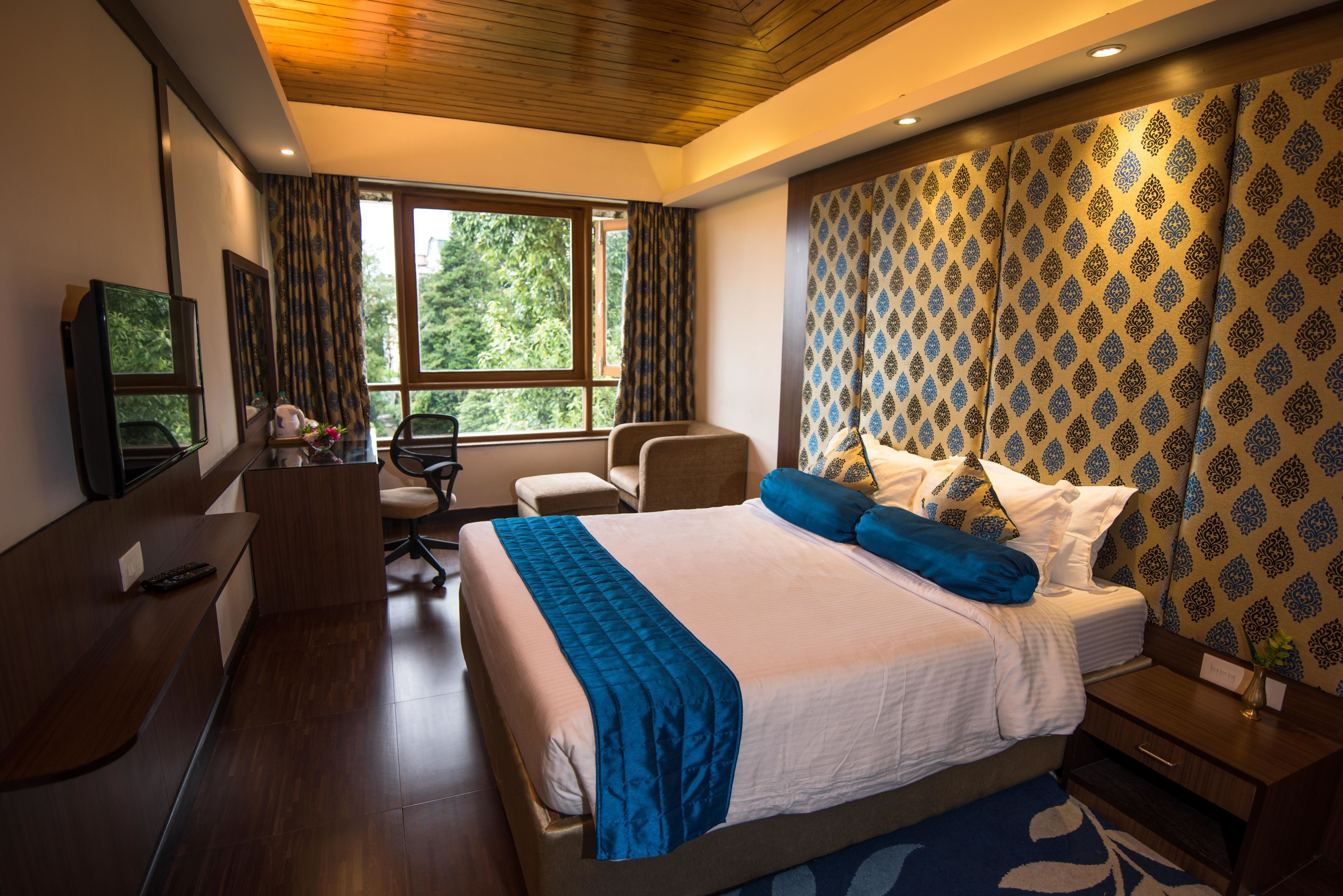 Een moderne hotelkamer met een groot bed, een bureau, een stoel en een televisie.