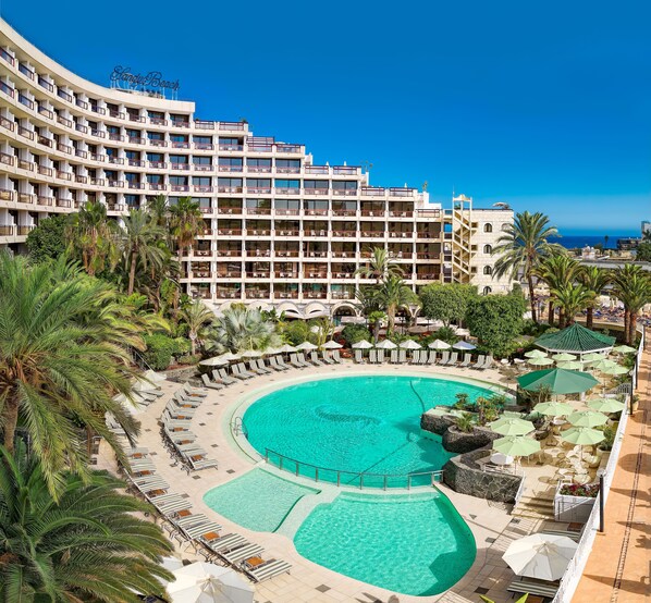 A hotel with a large pool, multiple balconies, and palm trees. - Seaside Sandy Beach (San Bartolomé de Tirajana)