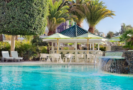 Una piscina al aire libre, sillones reclinables de piscina