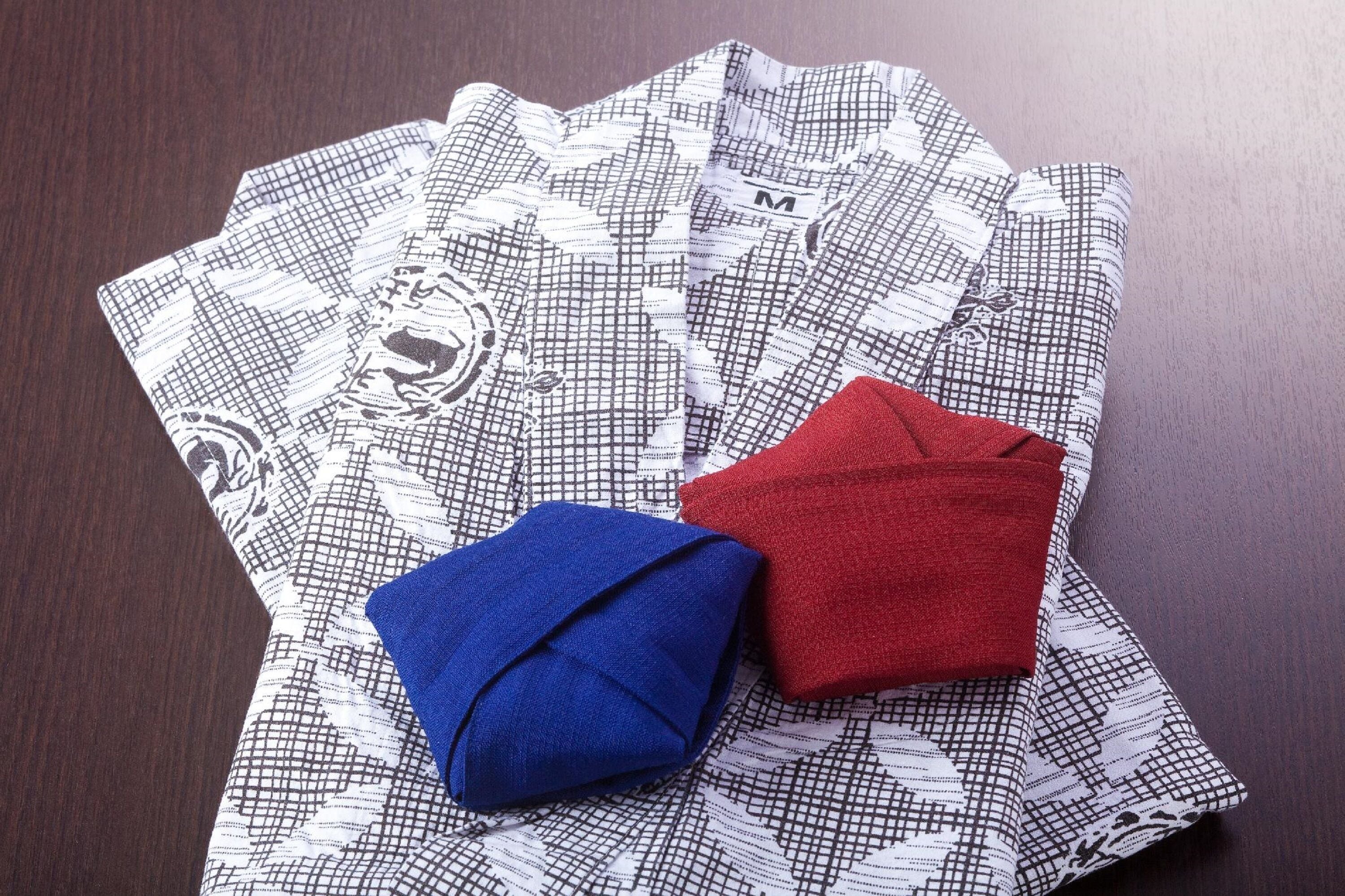 A patterned fabric with a folded blue and red item on it.