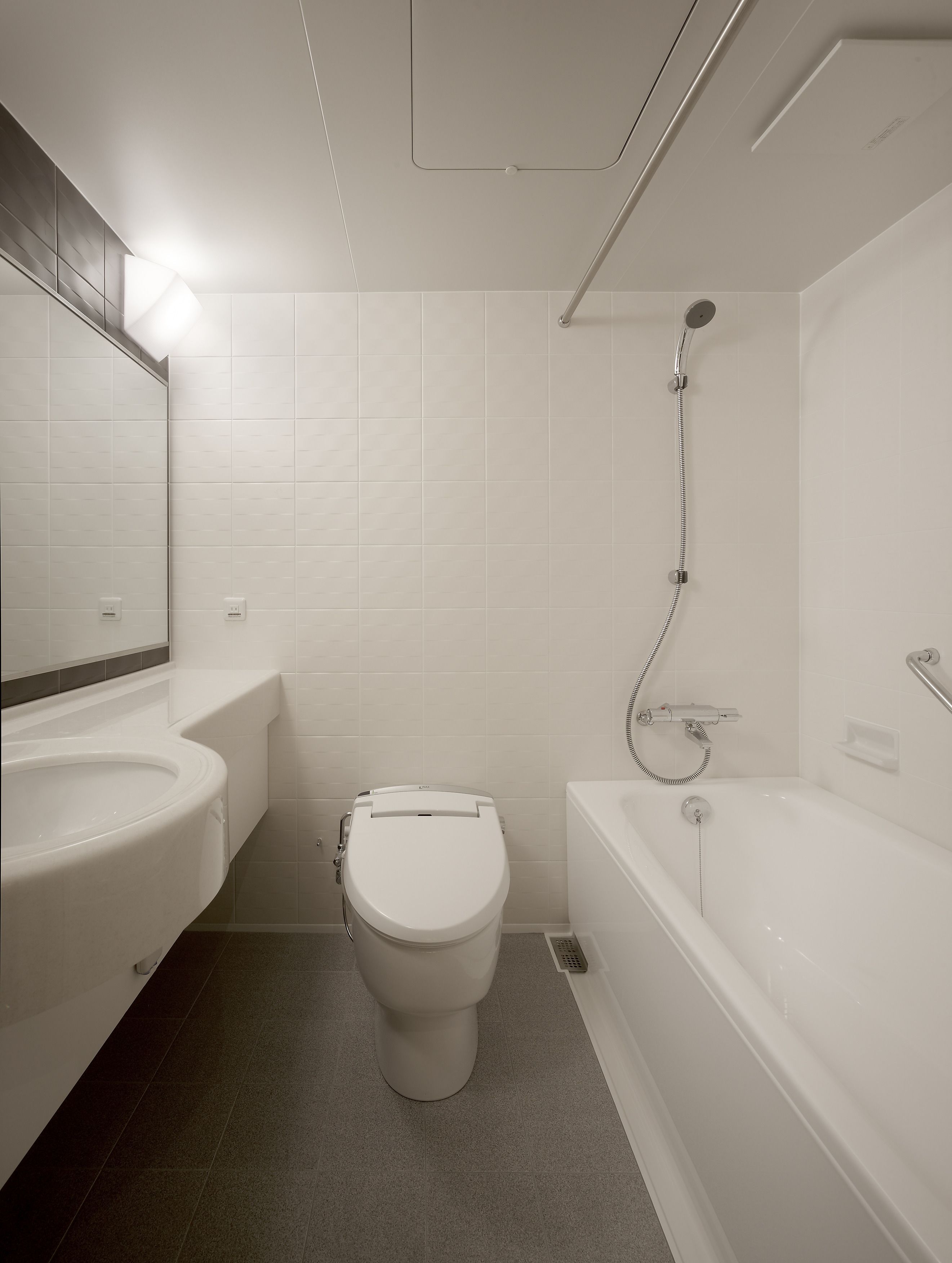 A modern bathroom with a toilet, sink, and bathtub.