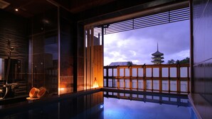 A traditional Japanese room with tatami flooring, a sliding door, and a view of a pagoda. - Asukasou (Nara)