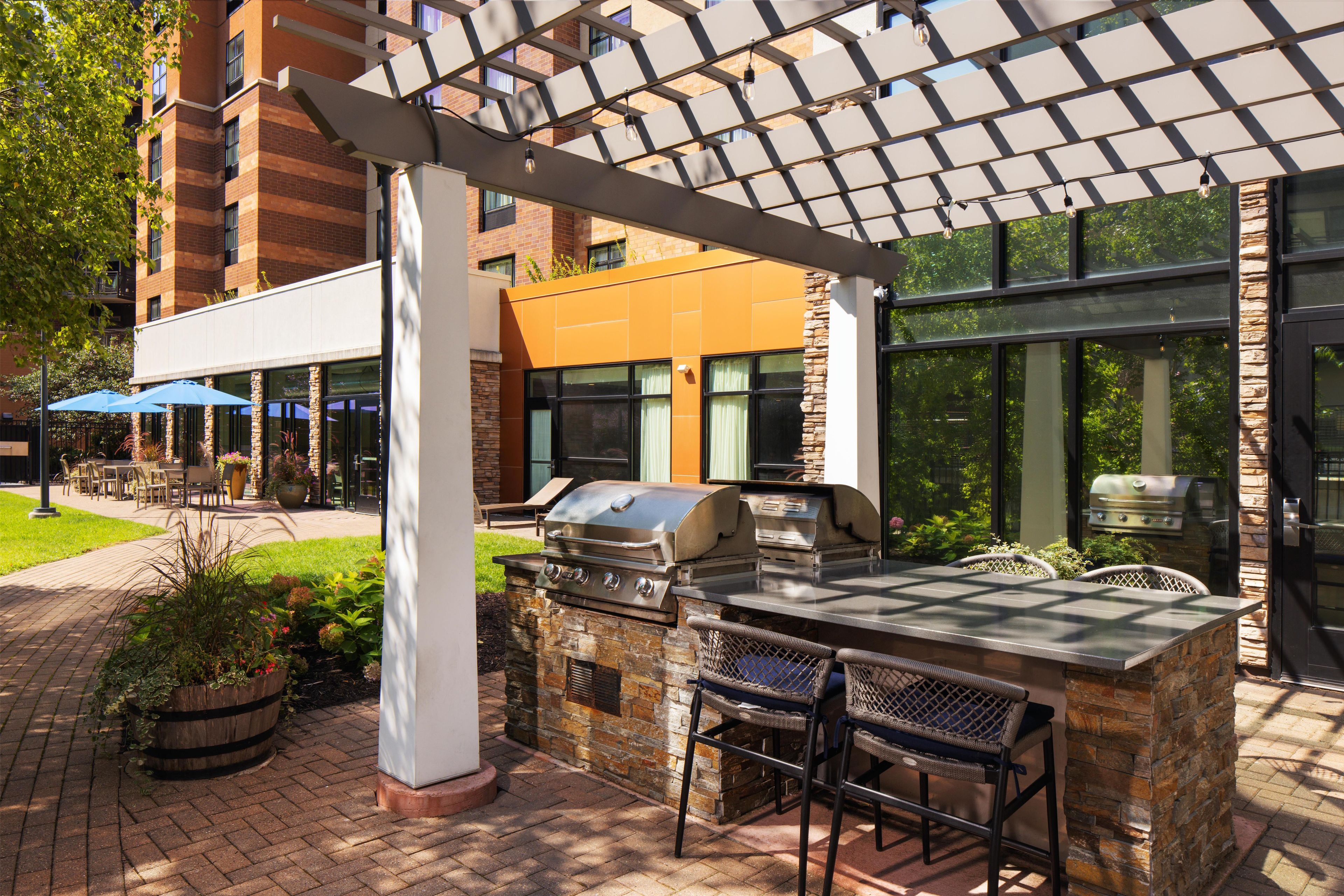 An outdoor patio area with a grill and seating.