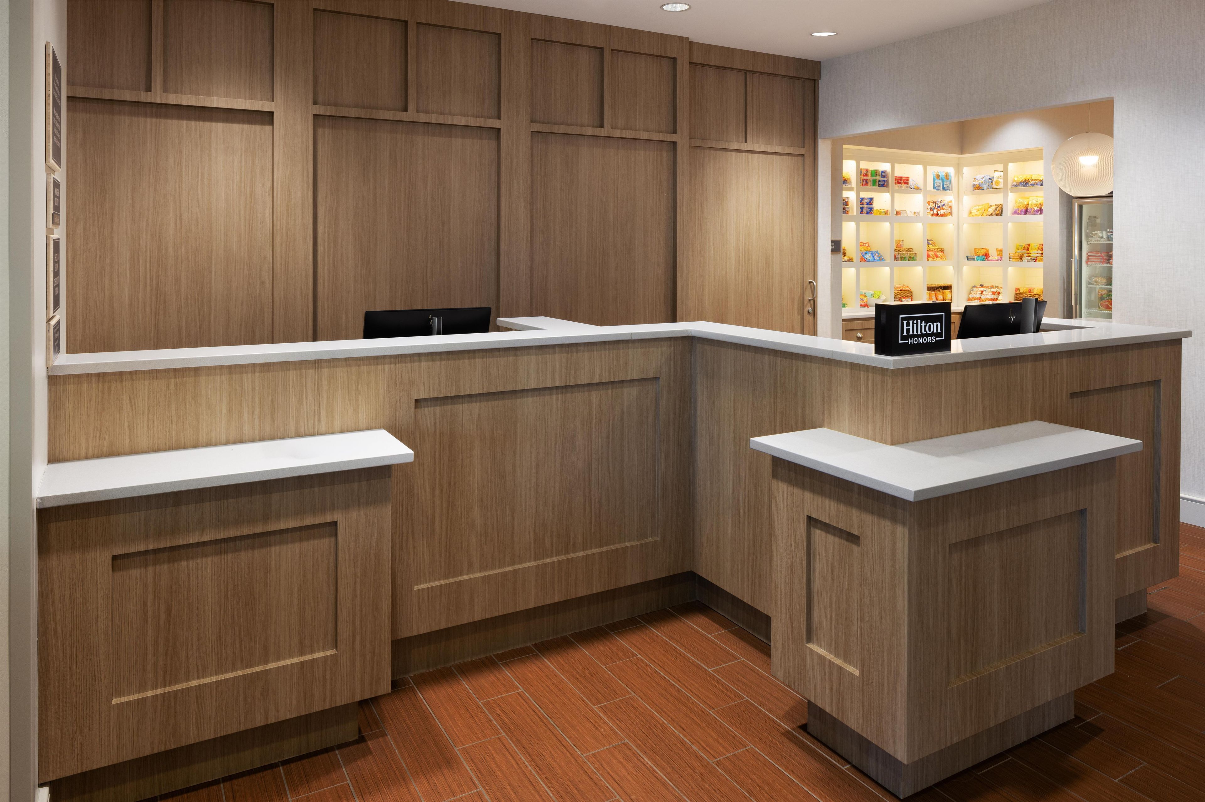 A hotel reception area with wooden paneling, a counter, and a minibar.