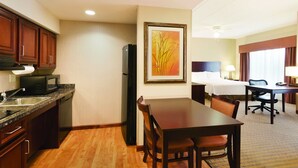 A hotel room with a kitchenette, a dining area, a bed, and a desk. - Homewood Suites by Hilton St Louis Park at West End (St. Louis Park)