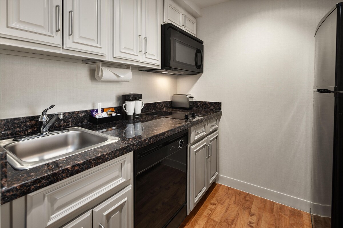A modern kitchen with a stainless steel sink, a microwave, and a dishwasher.