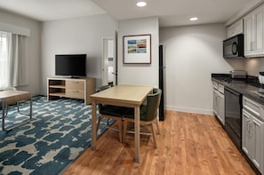 A compact living space with a kitchenette, a dining area, and a television. - Homewood Suites by Hilton St Louis Park at West End (St. Louis Park)
