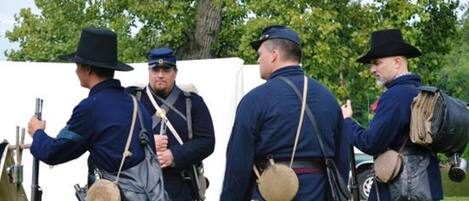 Een groep mensen in historische militaire uniformen staat buiten.