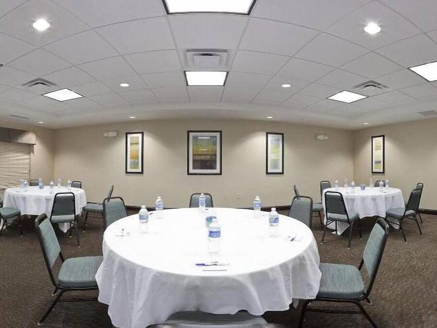 A conference room with round tables, chairs, and framed pictures on the walls.
