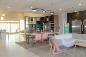 Un interior moderno con comedor, sofá y refrigerador.