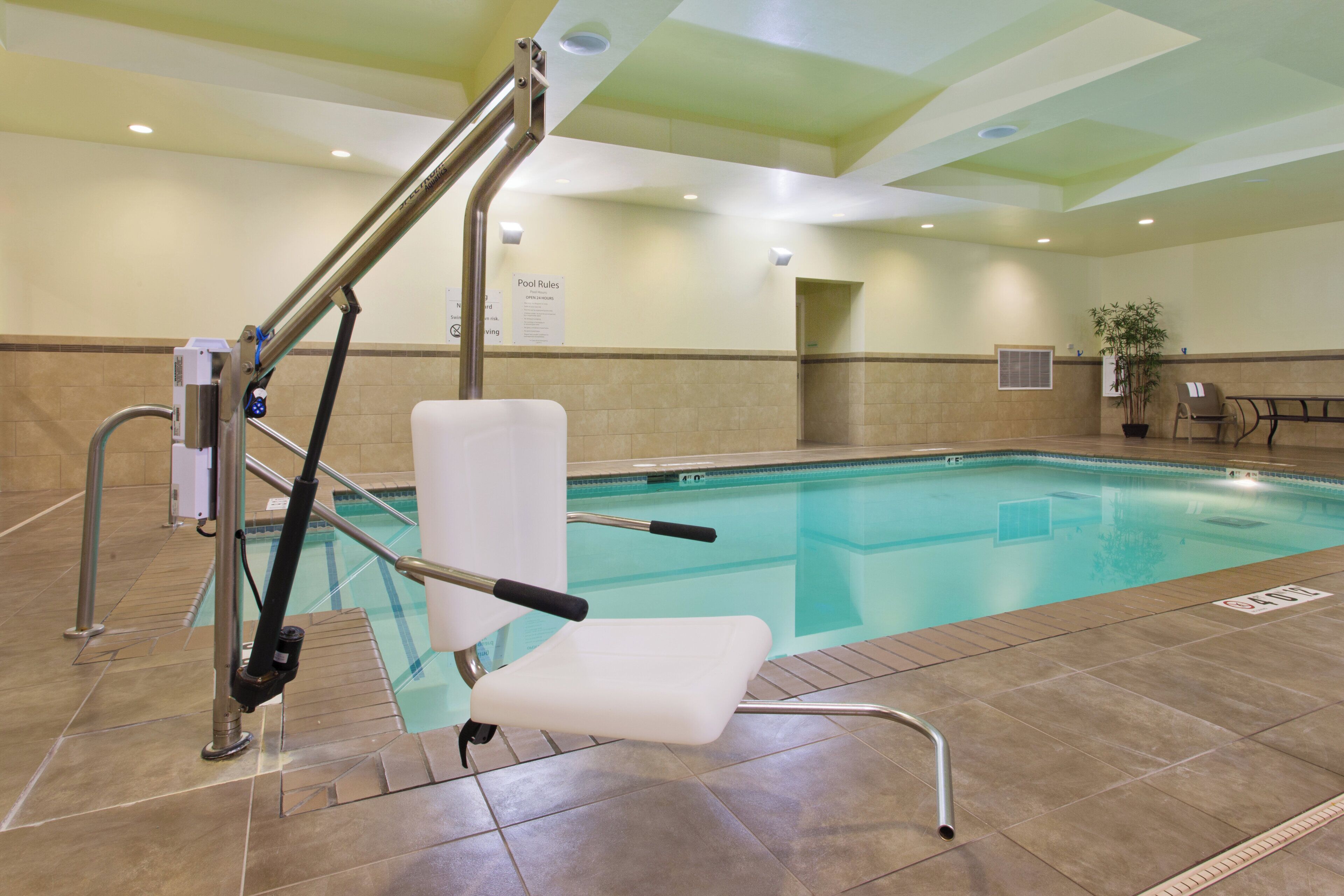 A swimming pool with a lifeguard chair and a pool ladder.