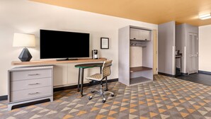 A hotel room with a desk, chair, television, and wardrobe. - Holiday Inn Yakima by IHG (Yakima)