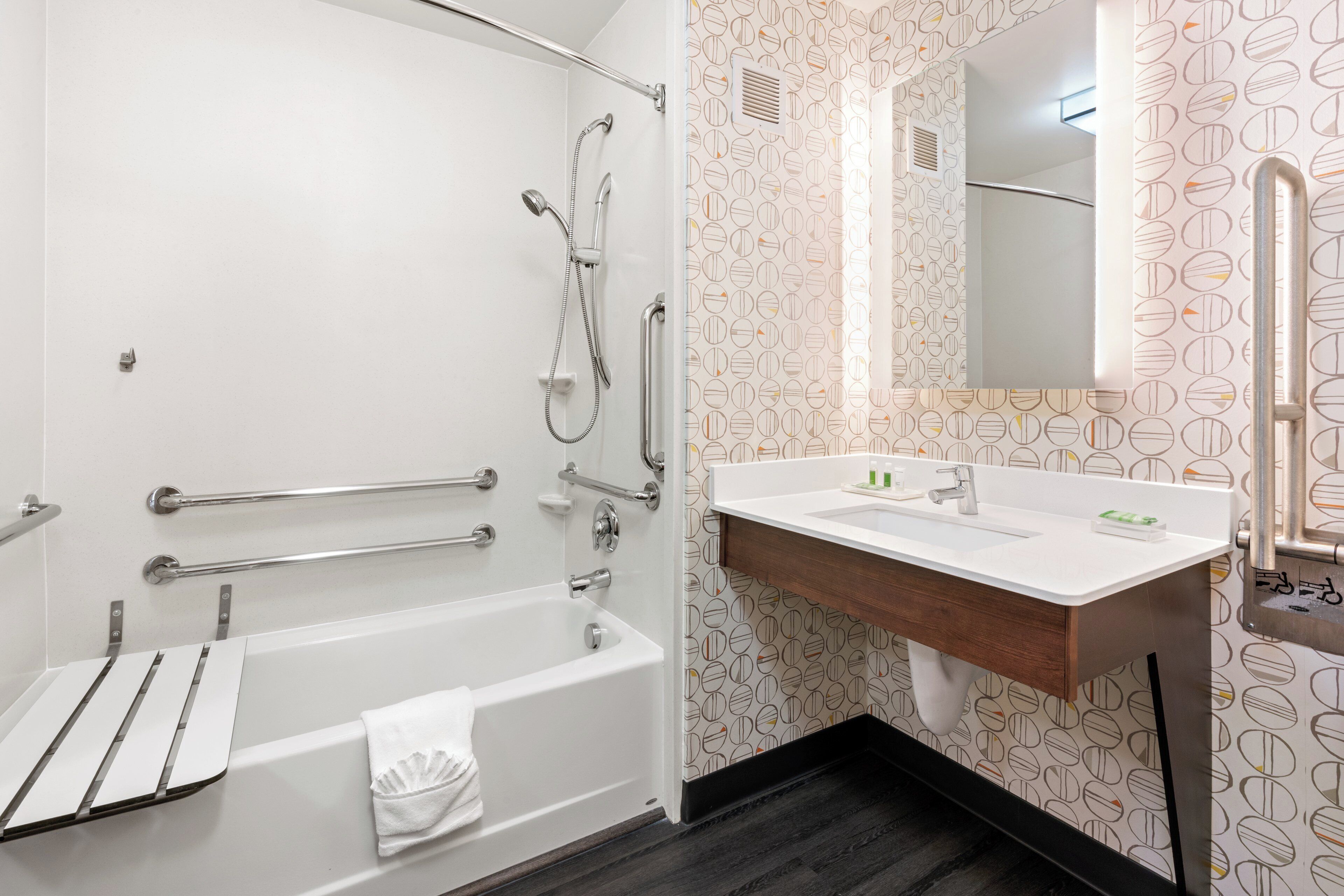 A modern bathroom with a bathtub, shower, and sink.