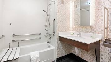 A modern bathroom with a bathtub, shower, and sink.