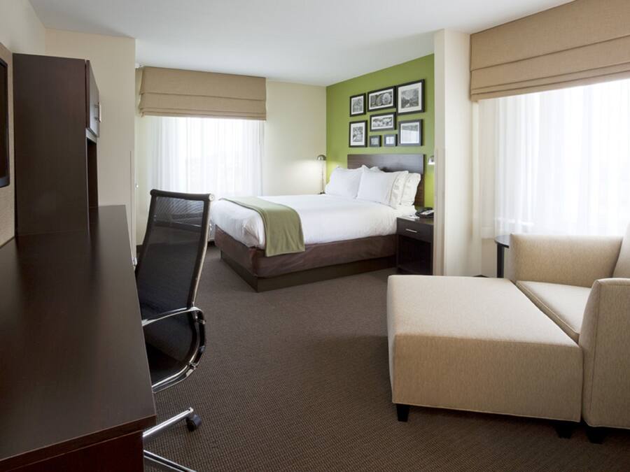 Ein Hotelzimmer mit Bett, Schreibtisch, Stuhl und einer Couch.