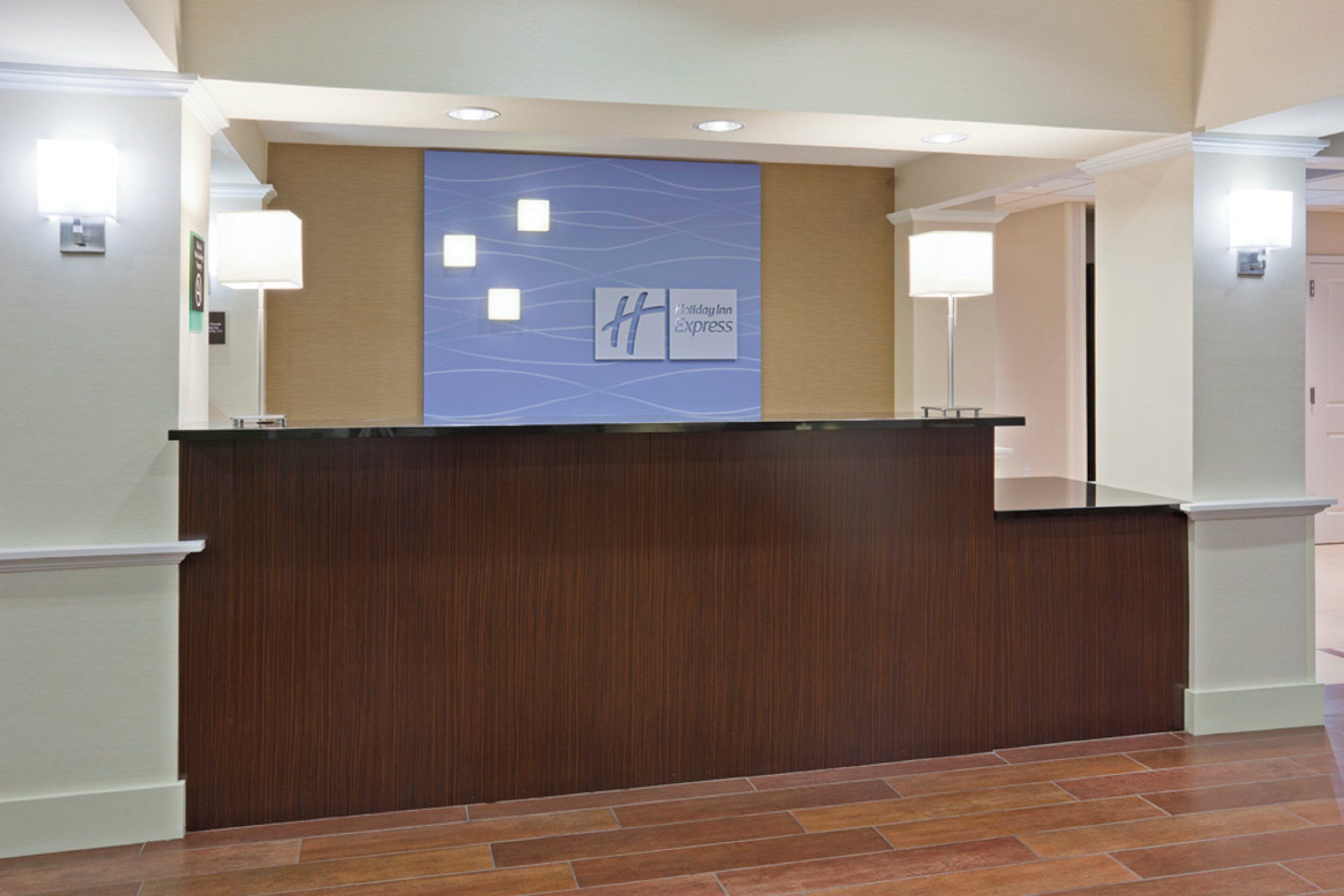 A reception desk with a blue sign indicating Holiday Inn Express.
