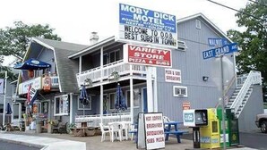 A motel with a sign advertising a variety store and pizza. - Moby Dick Motel (Old Orchard Beach)