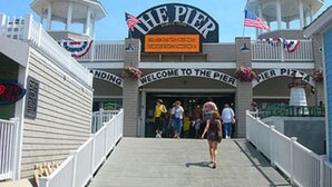 A pier entrance with a sign reading "Welcome to the Pier" and "Pier Pizza". - Moby Dick Motel (Old Orchard Beach)