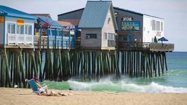 A beachside pier with a restaurant and a small building. - Moby Dick Motel (Old Orchard Beach)