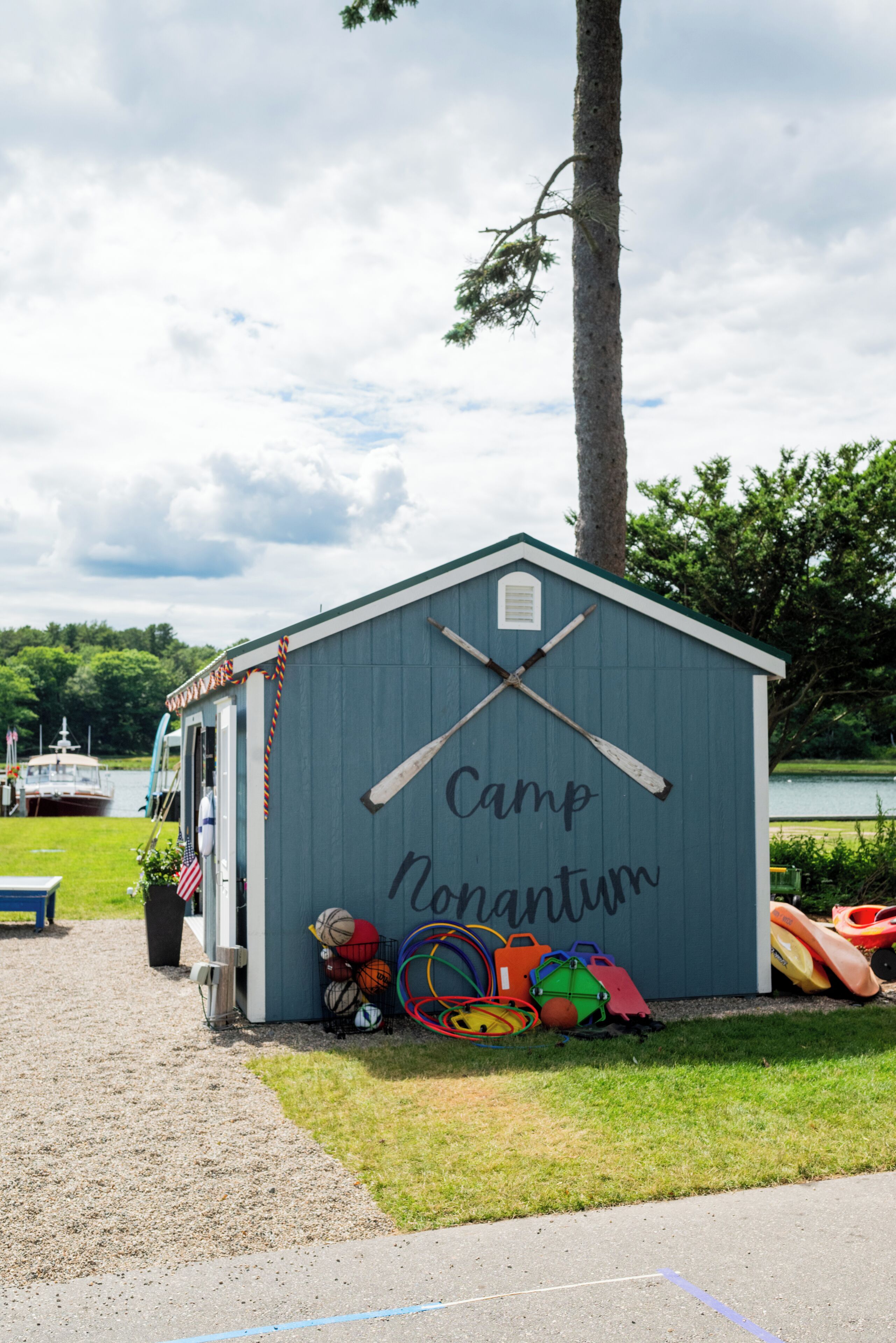 A small blue shed with the words "Camp Nonantum" and a baseball bat symbol on it.