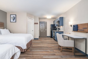 A hotel room with a bed, a desk, and a kitchenette. - Candlewood Suites San Antonio NW Near Seaworld by IHG (San Antonio)