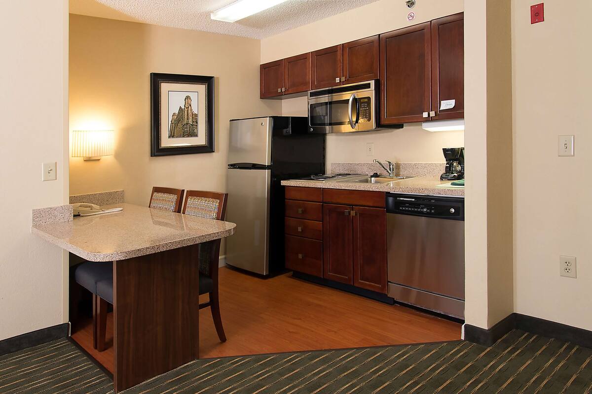 A compact kitchen with a refrigerator, microwave, and dishwasher.