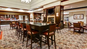 A spacious dining area with a long table, multiple chairs, a fireplace, and a television. - Homewood Suites by Hilton Toronto Airport Corporate Centre (Toronto)