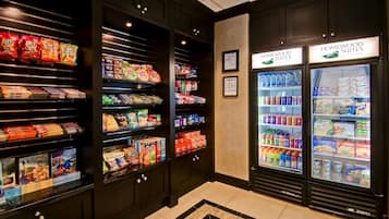 A hotel lobby with snack vending machines, refrigerated beverage dispensers, and a clean, modern design.