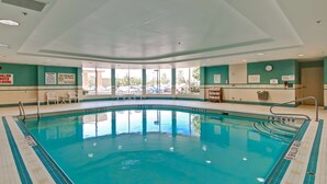 An indoor swimming pool with clear water, marked depth lines, and a view of the parking lot outside. - Homewood Suites by Hilton Toronto Airport Corporate Centre (Toronto)