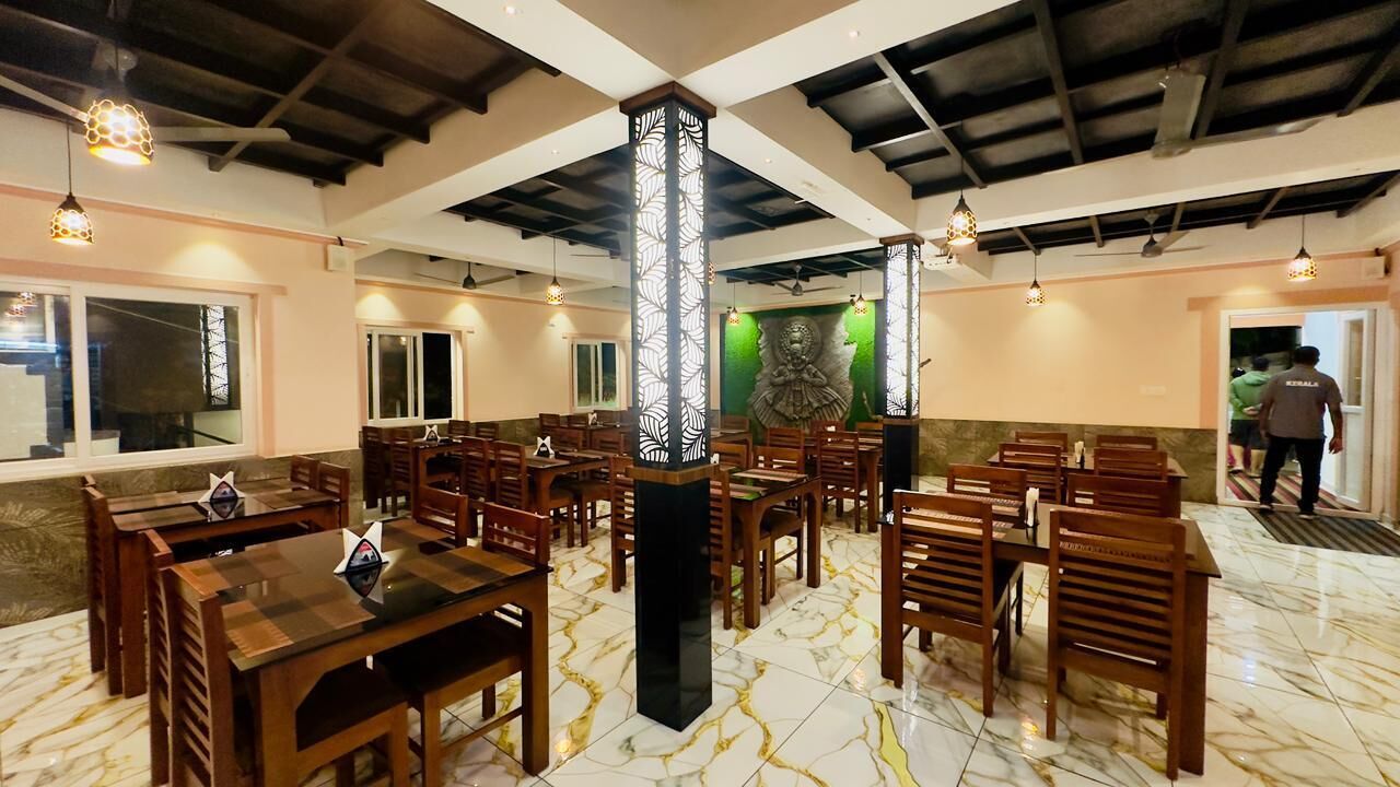 A restaurant with wooden tables and chairs, a marble floor, and a decorative pillar.