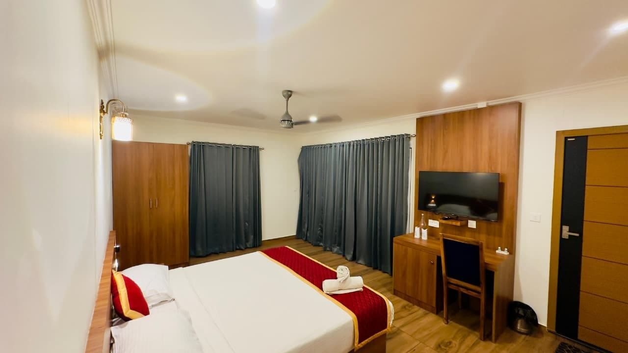 Une chambre d’hôtel équipée d’un lit, d’un bureau, d’une télévision et d’une armoire.