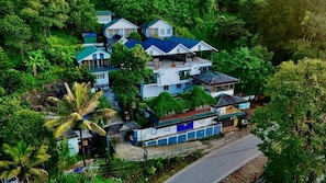 Um edifício residencial de vários andares rodeado por vegetação exuberante.