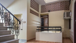 A staircase with a black railing leading to a landing with a white bench. - Jee Ri Haveli (Jodhpur)
