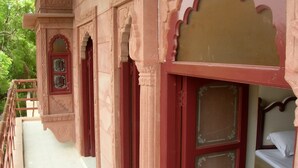 A traditional building with ornate architecture, including carved pillars and a balcony with a railing. - Jee Ri Haveli (Jodhpur)