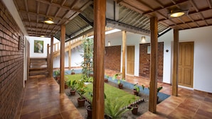 A covered courtyard with brick walls, wooden pillars, and potted plants. - Bracknell Forest (Udumbanchola)