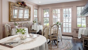 A dining room with a large mirror, multiple tables, chairs, and a view of the outside through large windows. - Bayfront Westcott House St Augustine B&B (St. Augustine)
