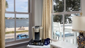 A coffee maker on a table by a window with a view of a beach and a road. - Bayfront Westcott House St Augustine B&B (St. Augustine)