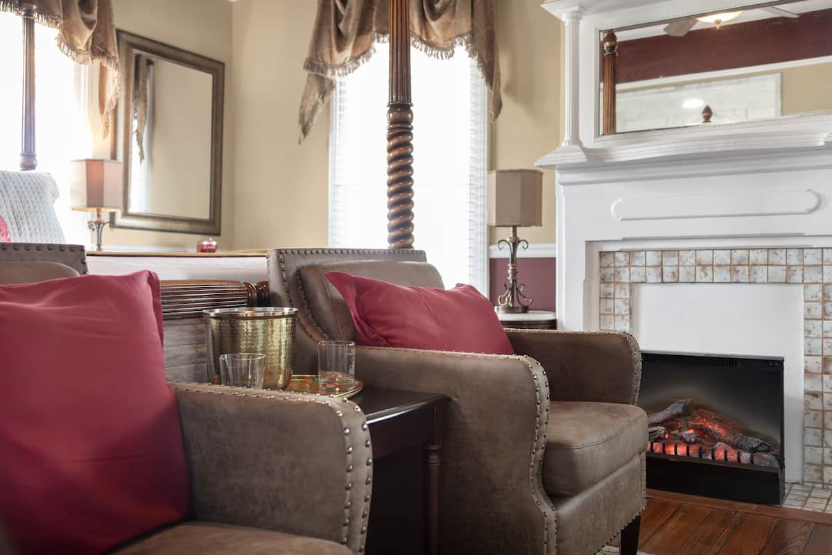 Una sala de estar acogedora con sillones de cuero, una chimenea y un espejo grande.