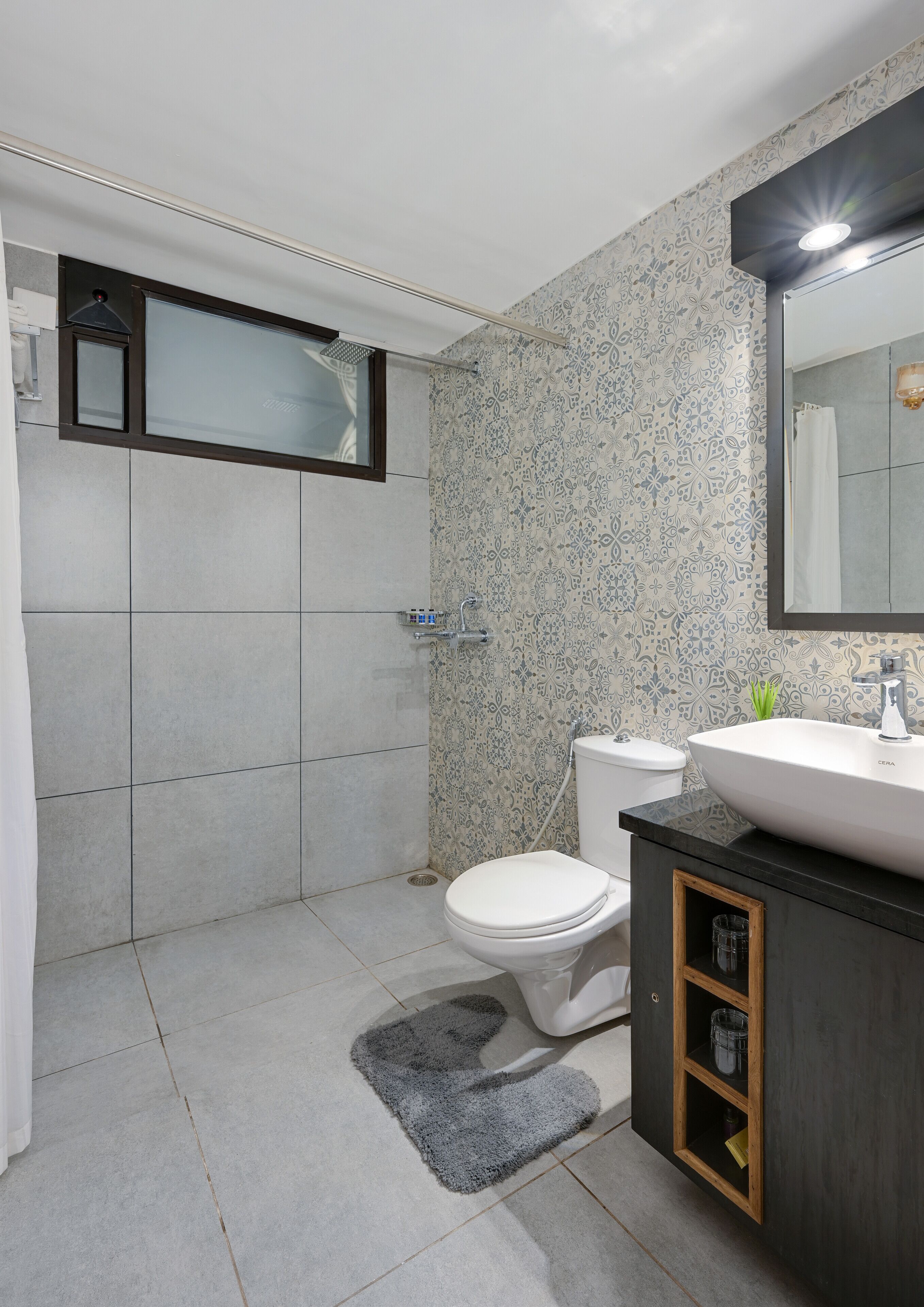 A modern bathroom with a shower, toilet, and sink.