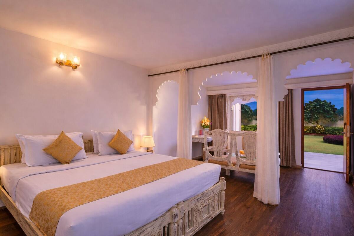 Une chambre avec un grand lit, un bureau et une vue sur l’extérieur.