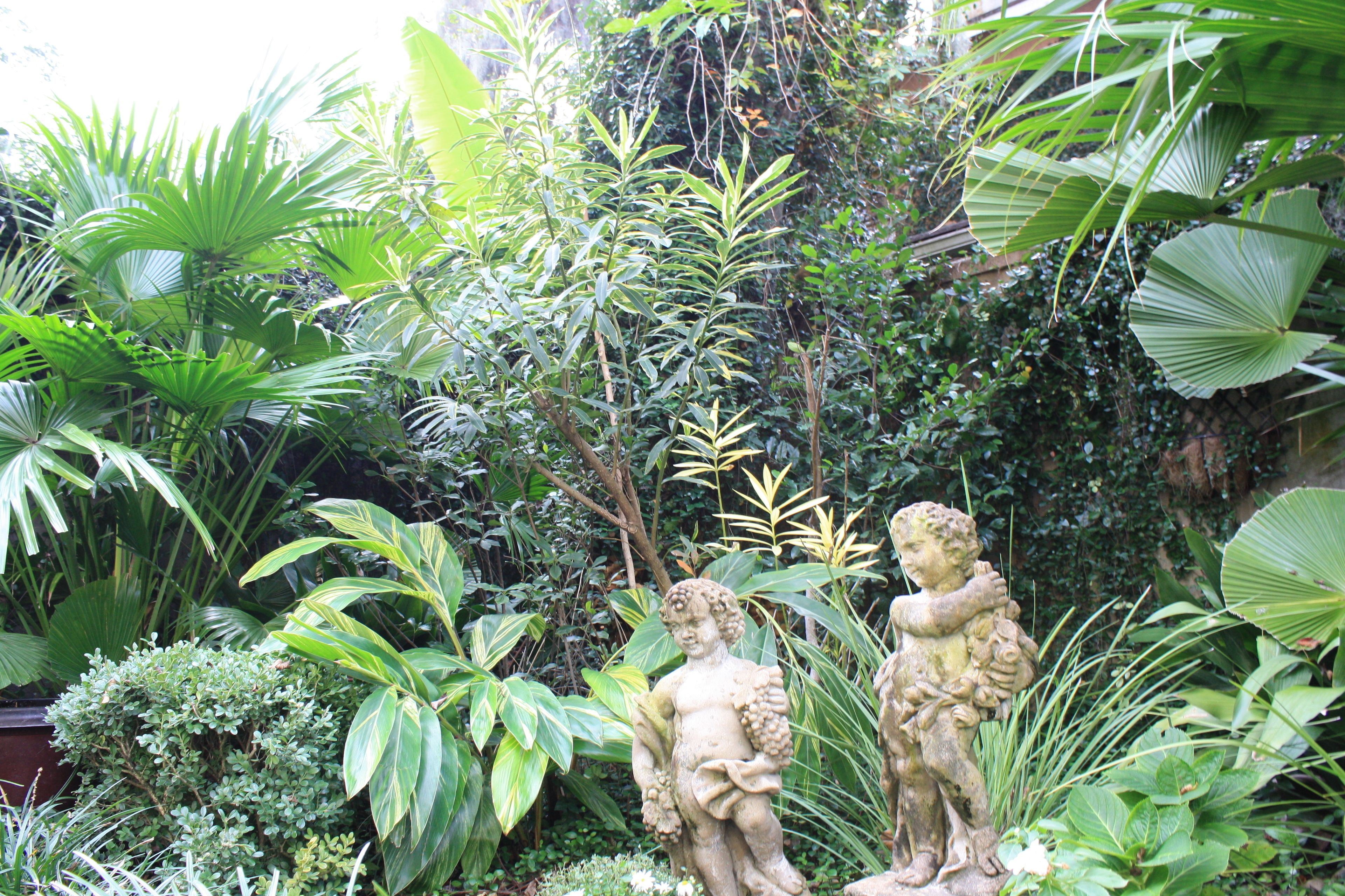 A garden with statues and lush greenery.