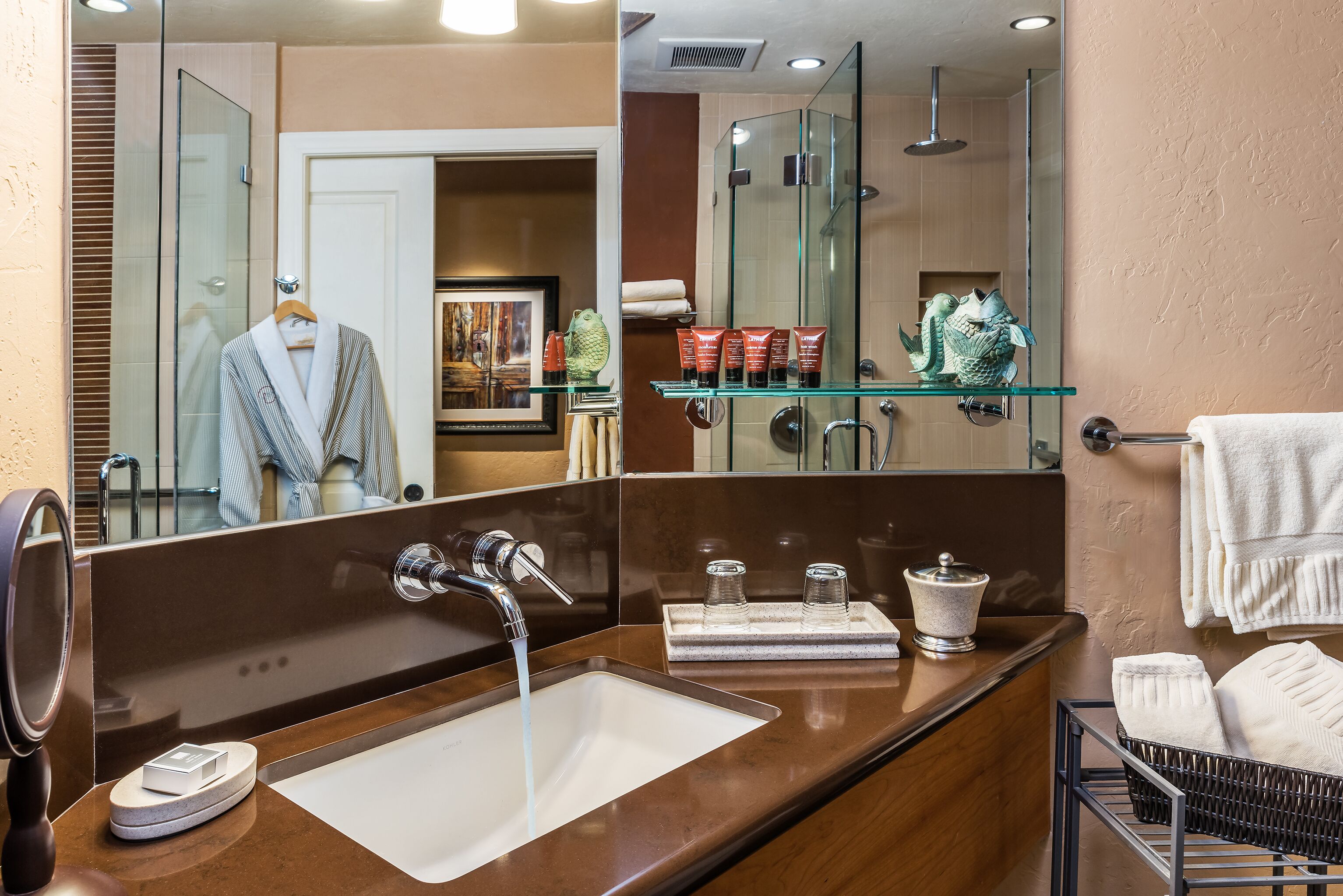Un baño moderno con un espejo grande, un lavabo y una cabina de ducha de vidrio.