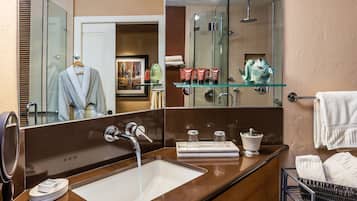 Un baño moderno con un espejo grande, un lavabo y una cabina de ducha de vidrio.