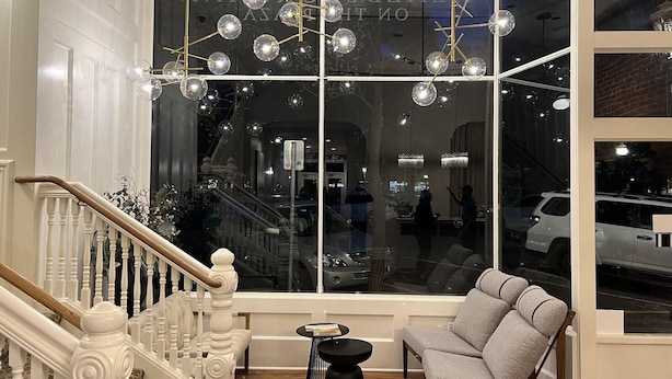 A modern interior with a staircase, a large window with reflections, and a seating area. - Healdsburg Inn on the Plaza, A Four Sisters Inn (Healdsburg)
