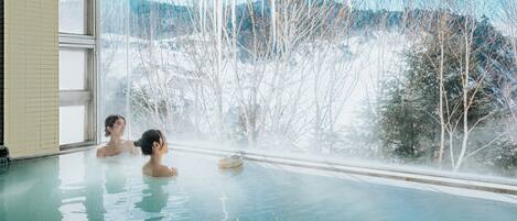 A hot tub with a view of a snowy landscape.