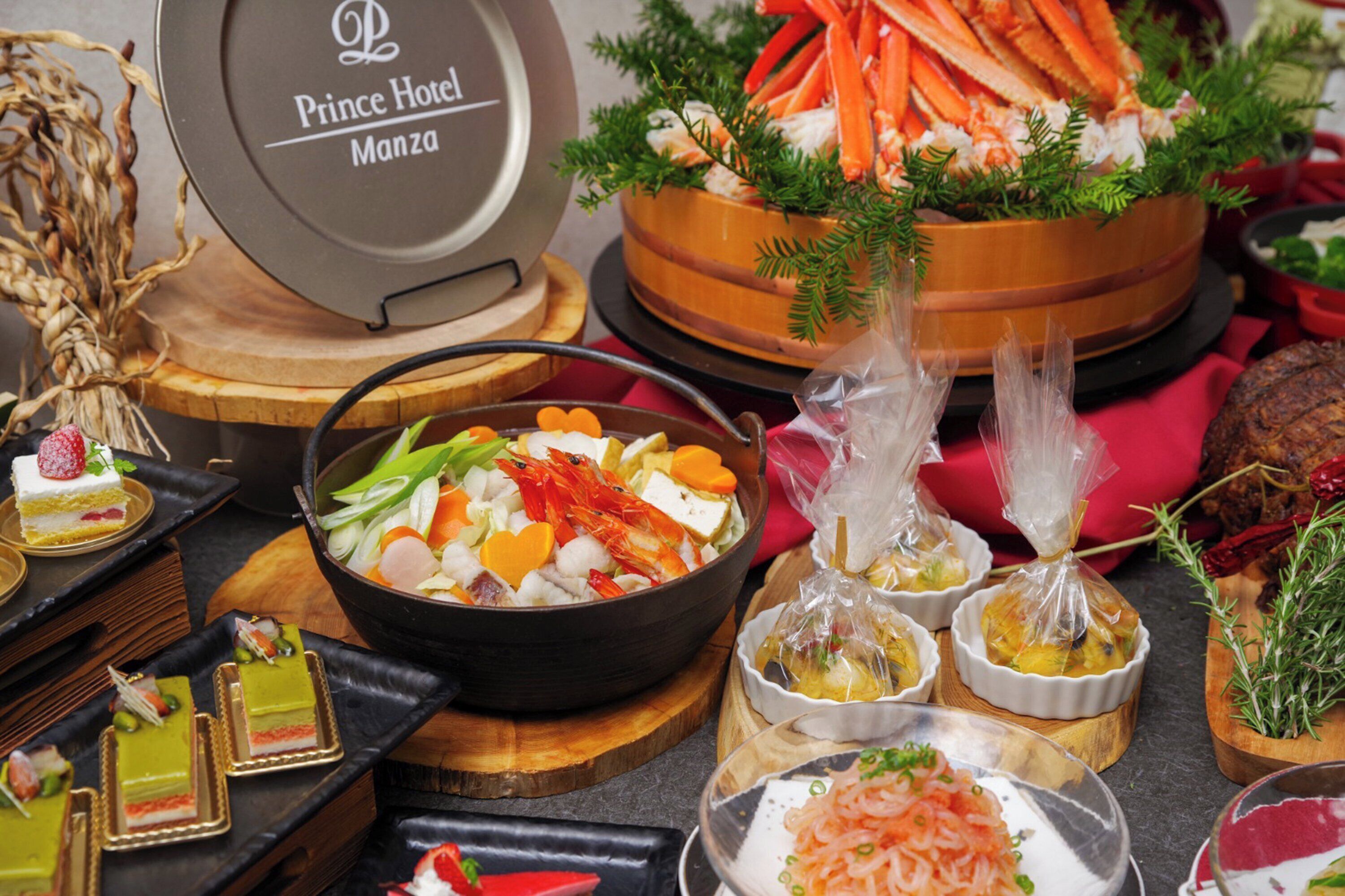 A variety of food items including seafood, vegetables, and desserts on wooden serving boards.
