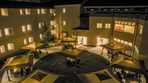 A courtyard with multiple tents and tables, surrounded by buildings with illuminated windows. - Manza Prince Hotel (Tsumagoi)